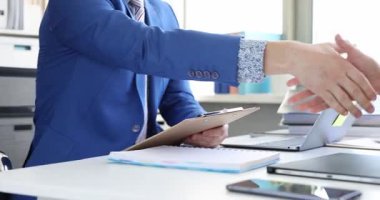 Dizüstü bilgisayarın yanında yönetici ve müvekkil arasındaki anlaşmayı gösteriyor. Meslektaşlar, ortaklar belgesini imzaladıktan sonra projeye başlamadan önce sözleşmeyi onayladılar