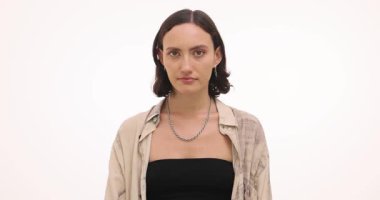 Genç bir kadın, minimalist bir stüdyoda bir dizi duyguyu tasvir ediyor, merak ve düşünce sergiliyor. İfadeleri, tarafsız bir arkaplan karşısında yavaş yavaş değişiyor..