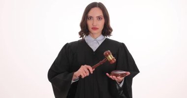 Yetenekli bir yargıç, parlak bir mahkeme salonunda elinde tokmak ve kase tutan siyah bir bornozla güvenle ayakta duruyor. Önemli kararlar vermeye hazırlanırken onun güçlü varlığına odaklanıyoruz..