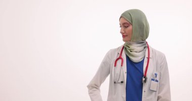 Müslüman kadın doktor, kopya için açık avuç içi sunum alanı sunuyor. Tıbbi uzman tesettür ve steteskop kullanıyor.