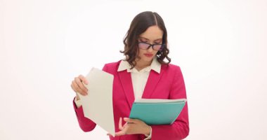 Kırmızı takım elbiseli bir kadın dosya dosyalarını düzenliyor. Dizin depolama işlemi sırasında kağıt yığını hareket ederken rapor eder