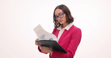 Stüdyoda kadın yöneticinin okuduğu rapor kafa karışıklığını ifade ediyor. Gözlüklerdeki kadın iş uzmanı, beyaz arka plan ile ilgili ticari bilgilerden şüphe duydu