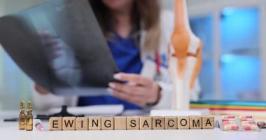 Tahta küplerle ilgili Ewing Sarkomu ifadesi ilaçlarla ve doktor klinikte kol ve bacak röntgeni görüntüsü tutuyor. Kemik ve yumuşak dokularda nadir görülen kanserli tümörler.