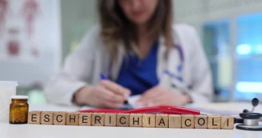 Tahta küpleri düzgün bir şekilde Escherichia Coli tabirine yerleştirilmiş. Doktor Escherichia Coli enfeksiyonu teşhisi konan hastalar için tedavi planı yazıyor.