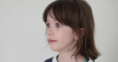 Genç kız şaşkın bakışlarla yana bakıyor. Ergenlik çağındaki bir çocuk, beklenmedik haberleri işleyerek stüdyoda şok ve merakla izliyor.