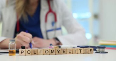 Tahta küplerde doktor masasında aşılama temasını vurgulayan poliomiyelit yazıyor. Paltolu kadın doktor klinikteki masada hastalıklarla ilgili notlar yazıyor.