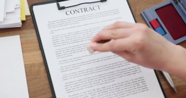 Kadın el, kontrat sayfasında reddedilen damgaya mesajla basıyor. Ofis çalışanı reddedilme kararını yavaş çekimde bitirirken panoyu sabit tutuyor