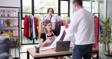 Kızgın müşteri, kuru temizlemedeki kadın yöneticiye büyük kan lekesi olan gömleği gösteriyor. Adam yerel çamaşırhanenin hizmetinden duyduğu memnuniyetsizliği dile getiriyor