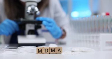 Tahta bloklar beyaz hapların ve petri kaplarının yanında ekstazi kelimesi heceleniyor. Mavi eldivenli bilim adamı, mikroskop altında tehlikeli izleri araştırıyor.