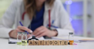 Tahta bloklar, cam şişelerin yanında panzehir kelimesini sıvılarla hecelerler. Kadın toksikoloji doktoru, acil durum protokolü için hayat kurtaran dozları hazırlıyor.