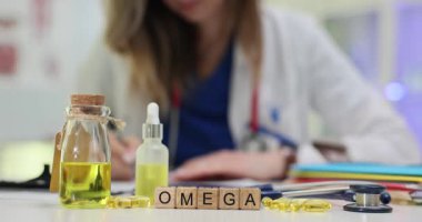 Omega kelimesi vitamin kapsüllerinin yanında tahta küplerde ve doktor masasındaki şişelerde yağ yağlarında. Hasta refahı için besin takviyesi önerisi