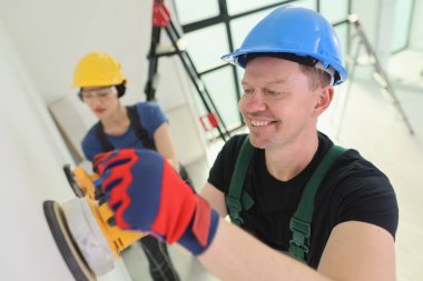 İki kendini işine adamış işçi, canlı bir inşaat ortamında görevlerine odaklanıyor. Biri, hem takım çalışmasını hem de kararlılığı gözler önüne sererken, diğeri dikkatle duvarı kumlar..