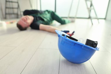 Kazadan sonra yerde mavi kasklı bir inşaat işçisi yatıyor. Sahne, iş yerindeki güvenliğin tehlikelerini çarpıcı bir şekilde yakalıyor..