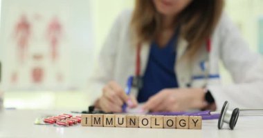 Doktor bağışıklık sağlığıyla ilgili detaylı tavsiyeler yazar. Tahta bloklar, tablet ve stetoskop kaplarının yanında kelime bağışıklık bilimi oluşturur.