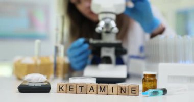 Ketamine, klinikteki kadın doktorlara karşı tahta küplerde ilaç kullanıyormuş. Mikroskop kullanan kadın kimyager laboratuarda narkotik maddeleri araştırıyor.