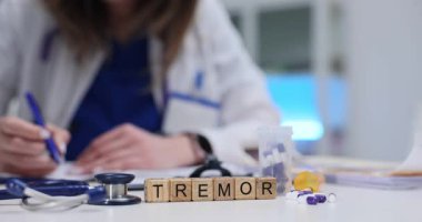 Tremor, tahta bloklarda steteskop ve masasında haplarla konuşuyor. Doktor hastanede istemsiz ritim kas kasılması ve gevşeme teşhisi koydu.