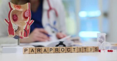 Klinikteki rektum anatomik modelli tahta bloklara paraproktiti yaz. Kadın doktor, hastane muayenesinden sonra hastanın tıbbi geçmişini dolduruyor.