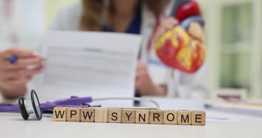 Tahta küplerde WPW Sendromu ve doktor masasında steteskop. Kadın doktor kalp anatomik modeli hastane kayıtlarını okuyor.