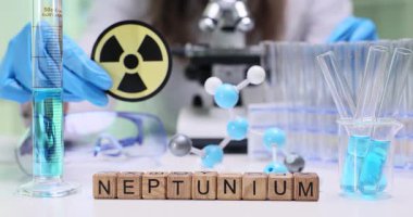 Tahta küpler, radyoaktif uyarı işaretinin yanındaki Neptunyum kelimesini heceler. Kadın doktor mavi solüsyonla ilgileniyor ve güvenli bir nükleer laboratuvarda tüpler üzerinde çalışıyor.