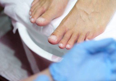 Eller yorgun ayaklara nazikçe bakar, sakin bir spa ortamında rahatlatıcı bir deneyim sağlar. Güneş pencereden hafifçe süzülür, rahatlamayı arttırır..