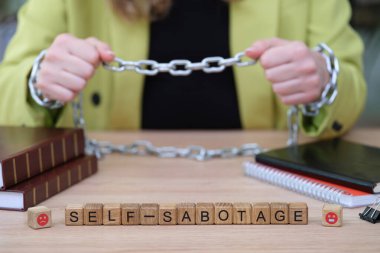 Parlak ceketli bir kişi, kendini sabote etme mücadelesini sembolize eden bir zinciri tutuyor. Kitaplar ve defterler, kişisel değişim ve büyümeye olan bağlılıklarını göstererek onları çevrelemektedir..