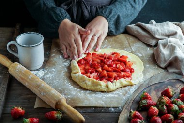 Taze çilek hazırlama süreci ile galette, genç kadın elleri, hamur ile çalışan