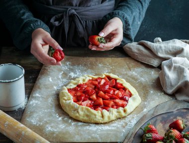 Taze çilek hazırlama süreci ile galette, genç kadın elleri, hamur ile çalışan