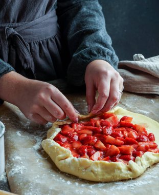 Taze çilek hazırlama süreci ile galette, genç kadın elleri, hamur ile çalışan