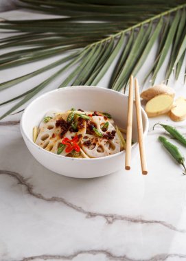 Beyaz taş arka planda baharatlı nilüfer kökü salatası, Asya yemekleri.