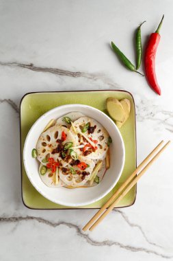 Beyaz taş arka planda baharatlı nilüfer kökü salatası, Asya yemekleri.