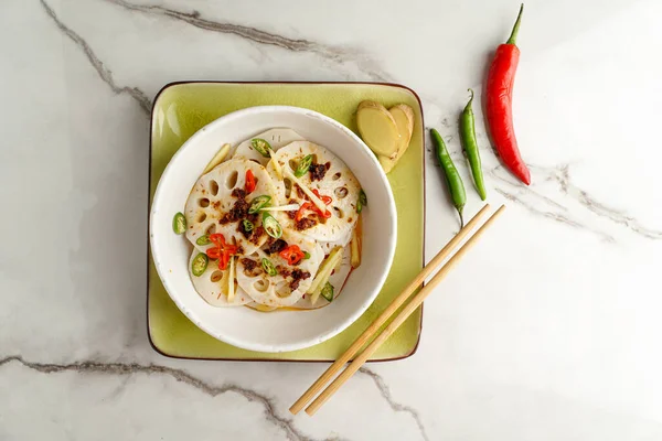 spicy lotus root salad on the white stone background, asian food