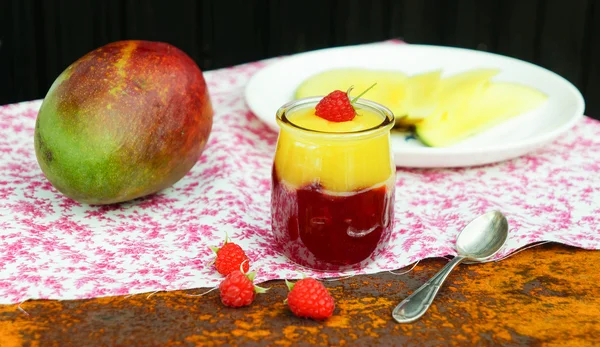 Манго и малиновый десерт в стеклянной банке — стоковое фото