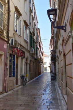 Akdeniz balkonunun cazibesi, Zadar 'da bir tatil sırasında sarı bir cepheye karşı ahşap panjurlarla kaplı..