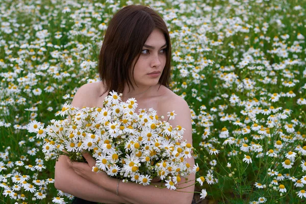 美丽的姑娘 戴着一束雏菊 在一片花地里 — 图库照片