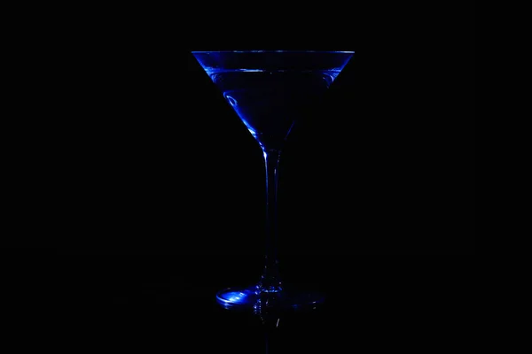 Martini-Glas mit blauer Farbe auf schwarzem Hintergrund. — Stockfoto