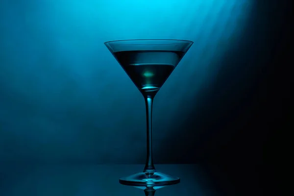 Martini-Glas mit blauer Farbe auf schwarzem Hintergrund. — Stockfoto