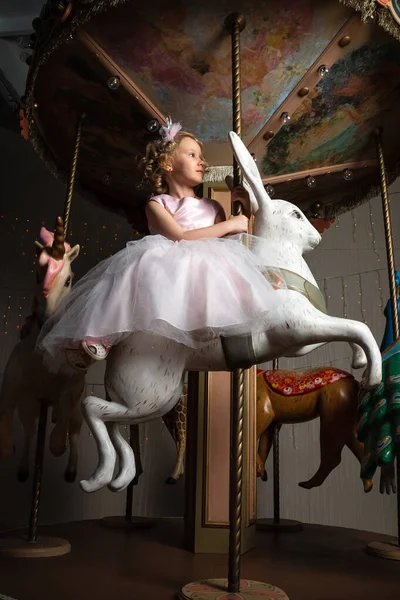 Mała Dziewczynka Różowej Sukience Korona Karuzeli Białym Zającem — Zdjęcie stockowe
