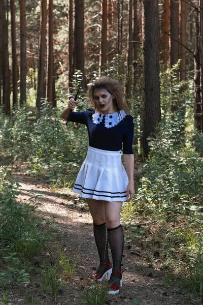 A zombie girl with an axe in her hands in a gloomy forest.halloween costume — Φωτογραφία Αρχείου