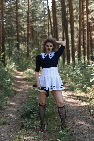 A zombie girl with an axe in her hands in a gloomy forest.halloween costume — Φωτογραφία Αρχείου