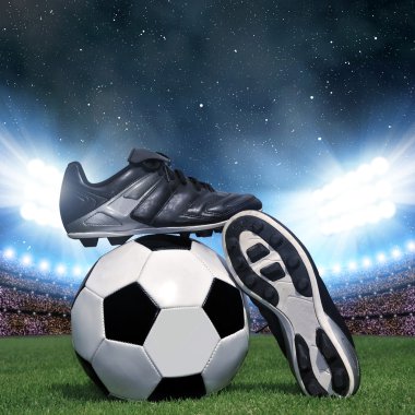 Soccer ball and shoes in grass clipart