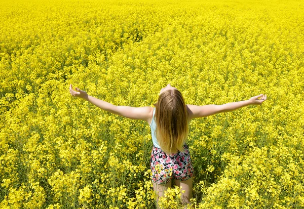Vrouw op bloeiende koolzaad veld — Stockfoto