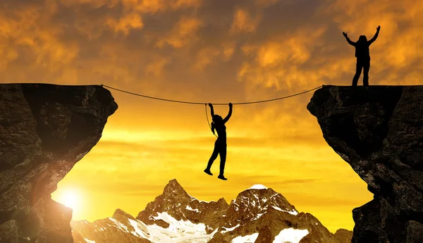 Silhouette girl climbs on a rope over an abyss — Stock Photo, Image