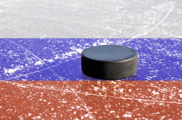 Black hockey puck on ice rink — Stock Photo, Image