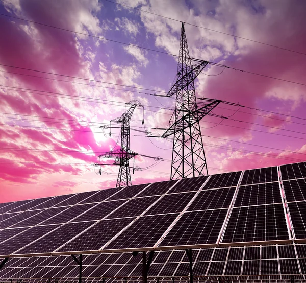 Paneles solares con pilones eléctricos al atardecer. — Foto de Stock