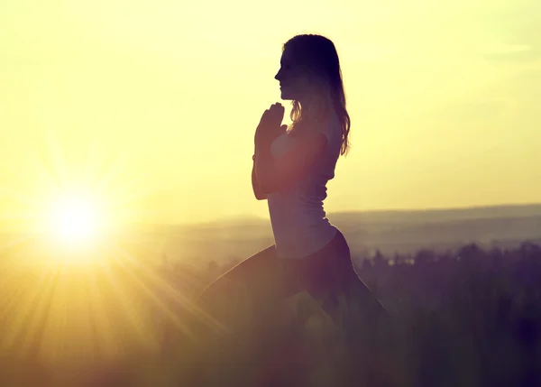 Silhouette einer meditierenden Frau auf einer Wiese — Stockfoto