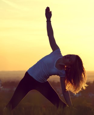 Genç kadın bir çayır üzerinde uzanan silüeti