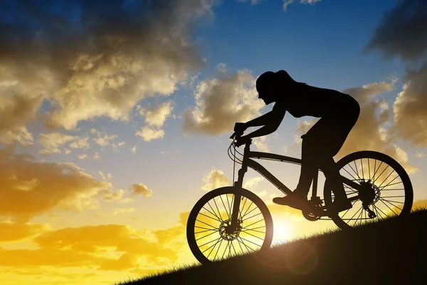 一个女孩骑着一辆山地自行车的剪影 — 图库照片