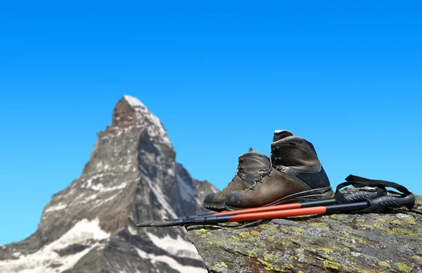 Zapatos de senderismo y postes en la roca — Foto de Stock