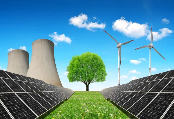 Sonnenkollektoren vor einem Atomkraftwerk und Windrädern. — Stockfoto