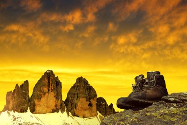 Gün batımında Tre Cime di Lavaredo arka planda kayada Hiking ayakkabıları